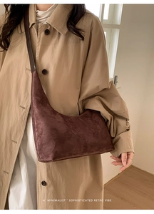 Minimalist dark brown suede hobo bag styled with a khaki trench coat for a retro vibe