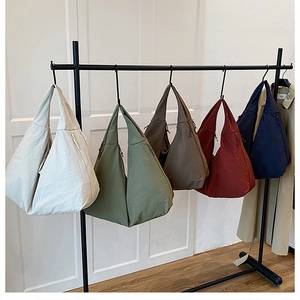 Detailansicht der halbmondförmigen Nylon-Einkaufstaschen in Beige, Grün, Braun, Rot und Blau