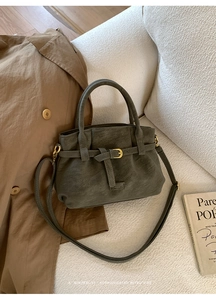 Detail of dark grey faux suede tote with decorative straps and adjustable shoulder strap
