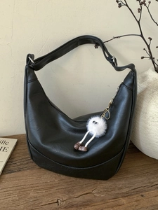 Chic black PU leather half-moon hobo bag with adjustable strap and plush charm