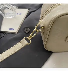Detailed macro of golden metal hooks and textured beige leather strap connection