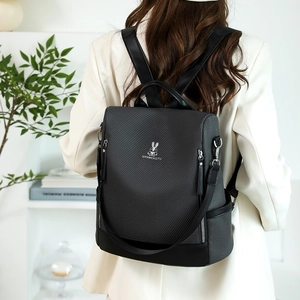 Detail of grey plaid backpack with leather base on model in a minimalist setting