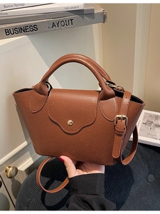 Elegant brown lychee pattern bucket bag with wave-shaped flap and gold buckle