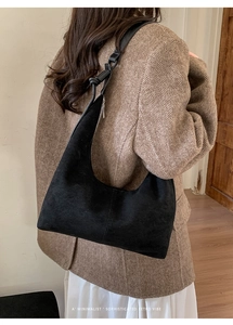 Detail shot of the minimalist black suede hobo bag with vertical stitching and retro vibe