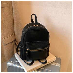 Vue détaillée du mini sac à dos noir avec surpiqûres blanches et fermetures éclair métalliques