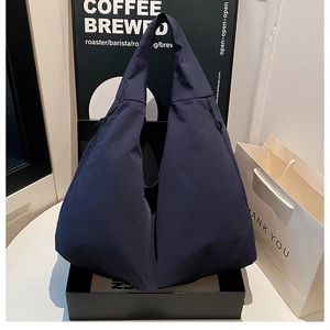 Makro-Detail der marineblauen dreieckigen Nylon-Tasche mit funktionalem Seitenreißverschluss