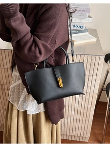 Chic black litchi pattern bucket bag with gold buckle shown on a modern lifestyle background