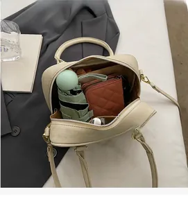 Interior view of cream suede Boston bag showing spacious storage for wallet and umbrella