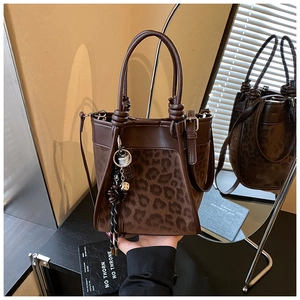 Détails du sac seau à imprimé léopard marron avec poignées en cuir et breloques à pompons chic
