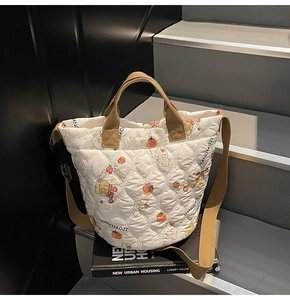 Close-up of quilted cotton bucket bag with cute animal patterns and adjustable strap