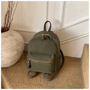 Vue détaillée d'un mini sac à dos en cuir vert olive avec ferrures dorées et poches latérales