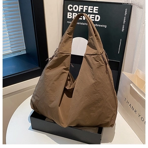 Detail einer großen kaffeebraunen Nylon-Einkaufstasche mit seitlichem Kordelzug