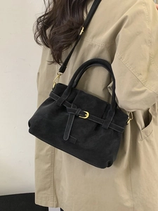 Minimalist black faux suede tote bag with gold buckle hardware shown on shoulder