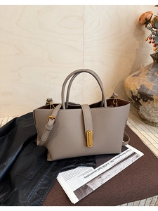 Detail of lychee textured leather and gold oval twist lock on a vintage bucket bag