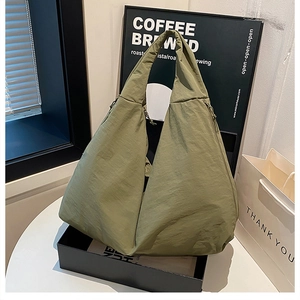Detail der armeegrünen Nylon-Hobo-Tasche mit seitlichen Kordelzügen und glatter Textur