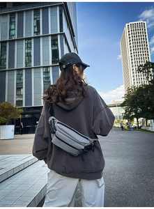Close-up of gray checkered chest bag with adjustable strap in street style setting