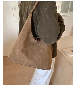 Minimalist caramel brown suede tote bag shown on a model in a bright studio