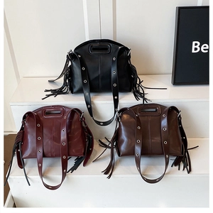 Detailed view of three vintage shoulder bags with side tassels in black, burgundy, and dark brown