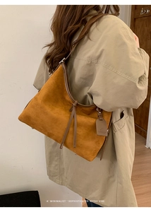 Détail de la matière en daim marron et de la longue tirette en cuir du sac cabas rétro