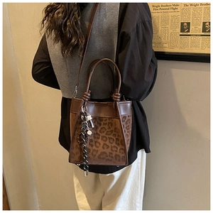 Détail du sac seau imprimé léopard marron foncé avec bandoulière amovible porté