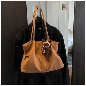 Close-up of vintage brown frosted tote bag with stitching detail and cute bear charm