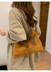 Détail du sac hobo en daim marron mettant en valeur la texture et le style rétro