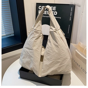 Detailansicht der Faltenstruktur und des Kordelzugs dieser beigen Canvas-Tasche