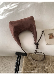 Close-up of suede hobo bag with knotted strap detail and sleek zipper closure
