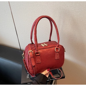 Detail of red suede Boston bag showing dual zipper closure and gold-tone metal hardware