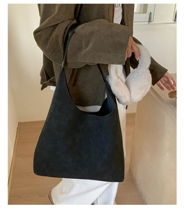 Detail of minimalist black suede hobo tote bag styled with casual autumn apparel