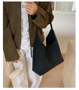 Detail of minimalist black matte tote bag with wide strap in a modern lifestyle setting