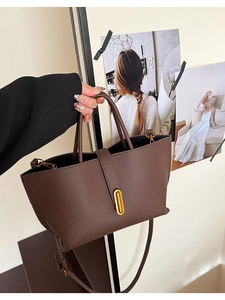 Detailed shot of dark brown lychee leather bucket bag with elegant gold metal lock