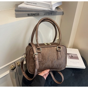 Detail of vintage bronze suede Boston bag with vertical texture and metal hardware