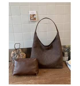 Detail of dark brown suede hobo bag with a matching small leather zipper pouch