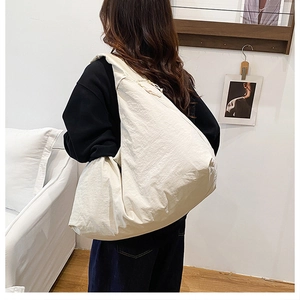 Detail der cremeweißen Oversize-Canvas-Tasche mit weichem Nylonstoff und Reißverschluss