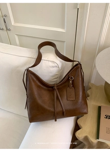 Détail du sac hobo marron rétro avec texture en cuir PU et étiquette de marque