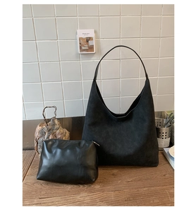 Close-up of black hobo shoulder bag set with matte suede texture and small pouch