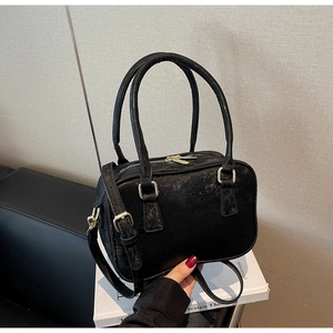Detail of vintage black suede Boston bag with gold hardware and adjustable strap