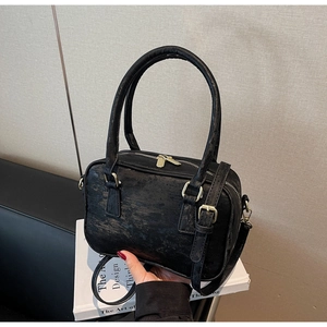 Detail view of black vintage suede Boston bag with matte gold hardware and textured finish