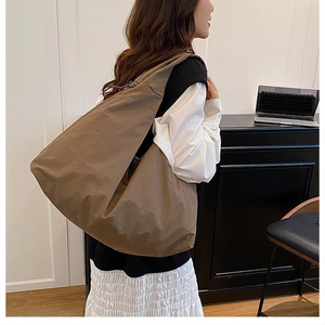 Nahaufnahme der braunen Canvas-Einkaufstasche mit Falten-Design und breitem Schultergurt