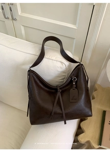 Détail d'un sac cabas en cuir mat marron foncé au design minimaliste rétro Hobo