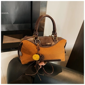 Detail of vintage patchwork handbag featuring leather bow and dual color pompom charms