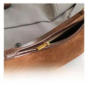 Detailed close-up of premium gold zipper and brown crocodile texture on baguette bag