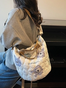 Quilted oversized shoulder bag with koala print and adjustable brown straps shown on model