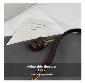Detail of adjustable chocolate brown faux leather strap with golden metal swivel hook