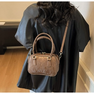 Brown suede Boston bag styled with a black leather coat for a modern autumn outfit