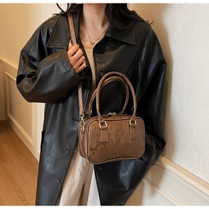 Detail of vintage suede Boston bag showing brown textured material and gold hardware