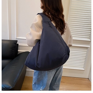 Detail einer großen dunkelblauen Nylon-Einkaufstasche mit breitem Schultergurt