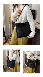 Detail of black tote bag with white polka dots and woven handles on a model