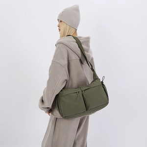 Dettaglio della borsa a tracolla verde oliva con tasche multiple e chiusura a coulisse